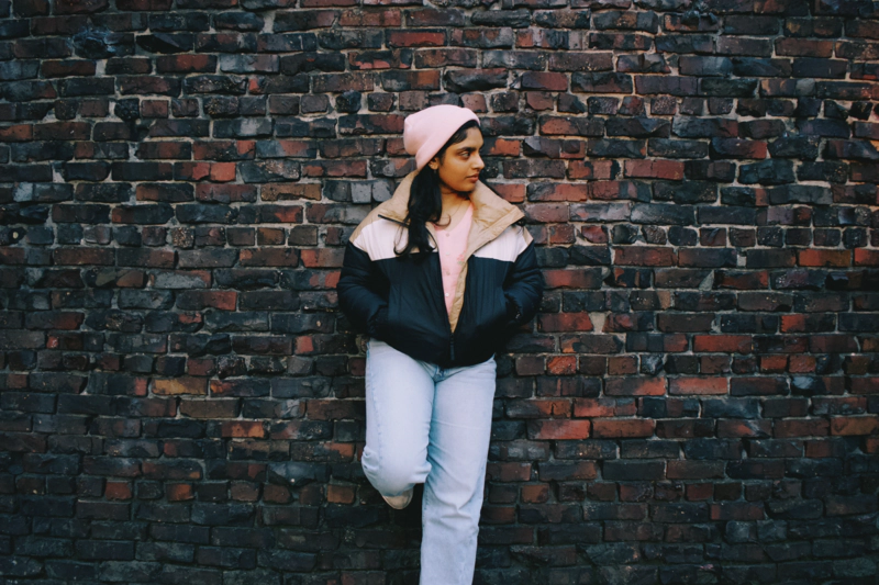 srujani-posing-at-brick-wall.jpeg